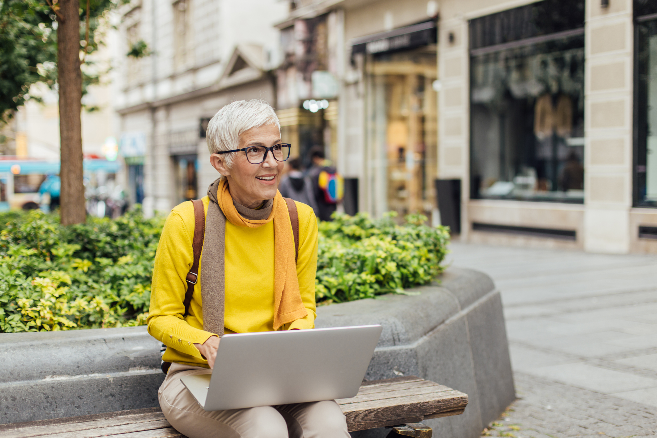 Image of mature woman sitting outside and working on laptop